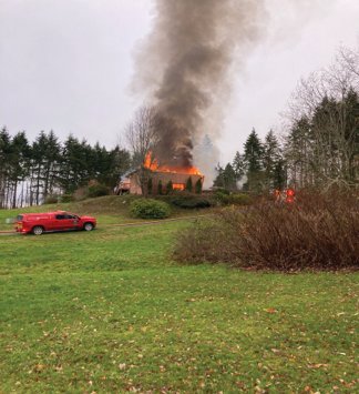 Firefighters battle a fire at a Port Ludlow home Monday.